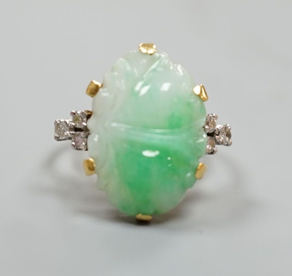 An 18ct, carved jade cabochon and diamond set oval dress ring, size O, gross weight 6.2 grams.